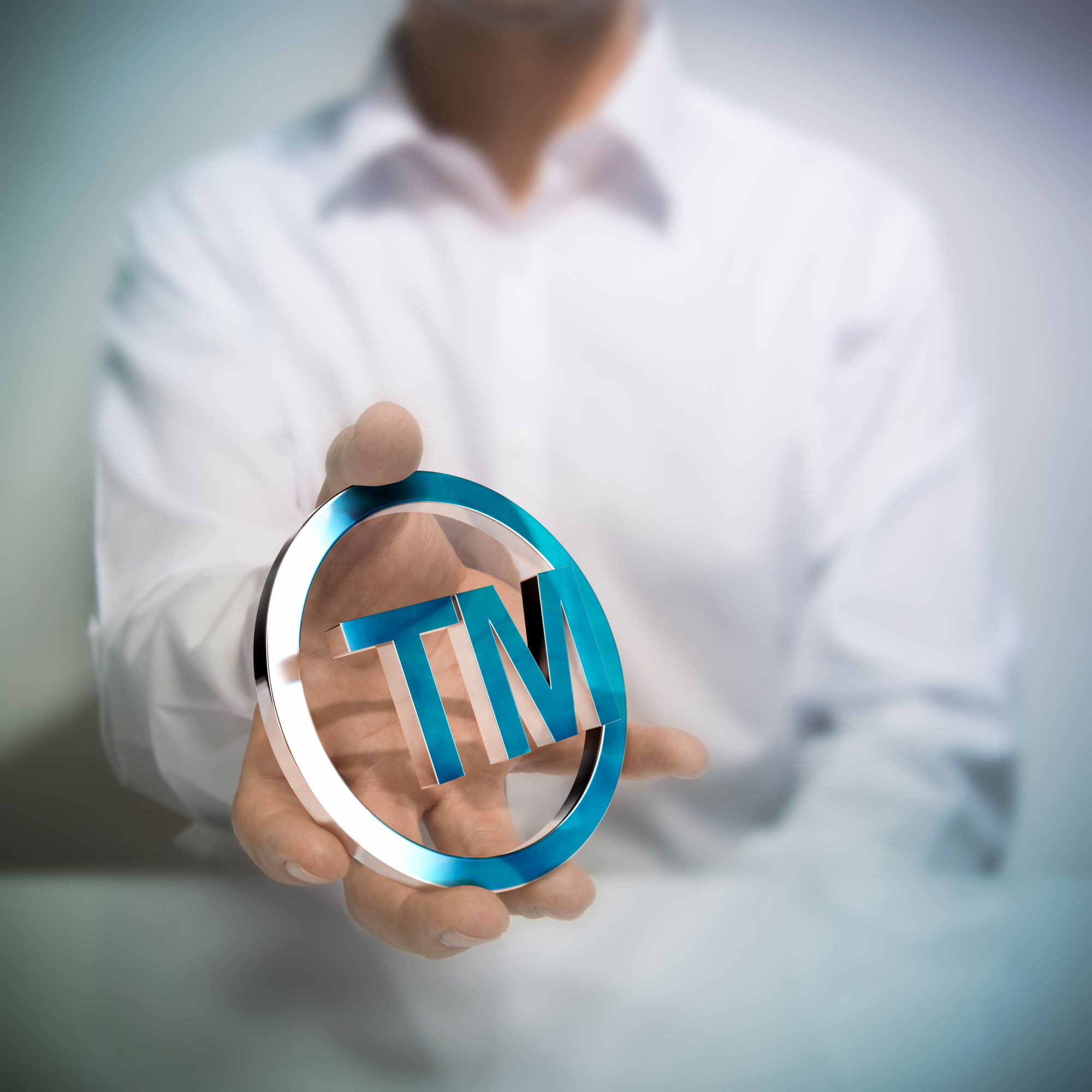 man-holding-metallic-trademark-symbol-concept-image-illustration-intellectual-property-protection-products-services1